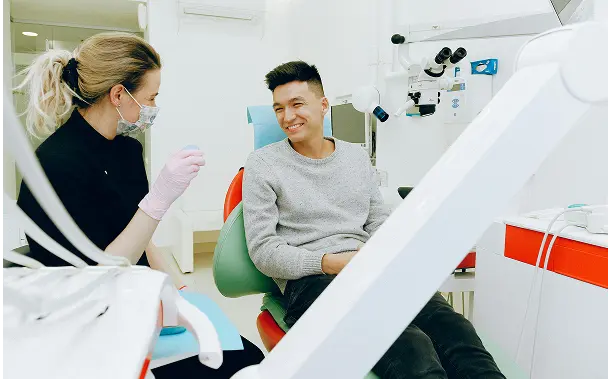 happy man at dentist because of good dental employee benefits