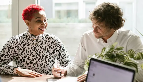 two young people reviewing health insurance quotes happy